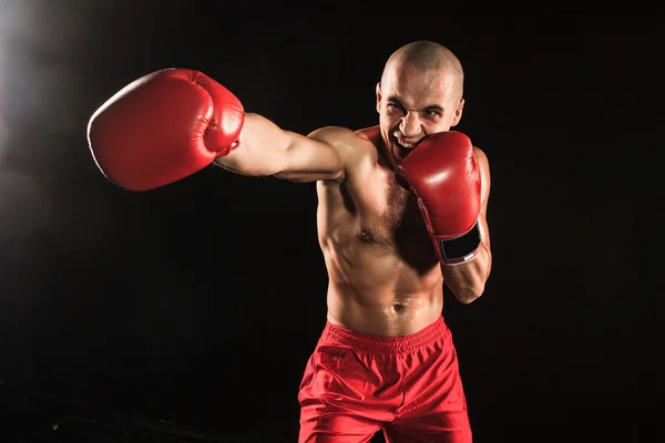 The young man kickboxing on black — Stock Photo, Image