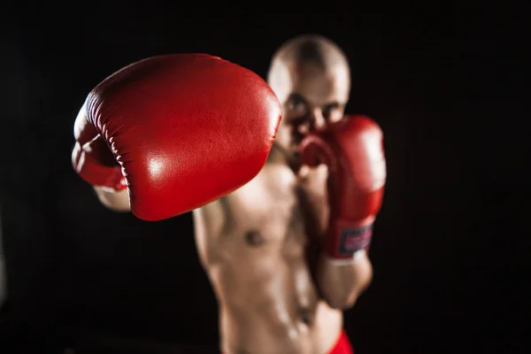 The young man kickboxing on black — Stock Photo, Image