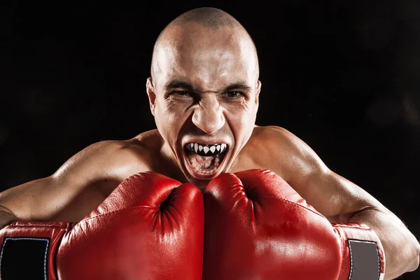 The young man kickboxing on black  with kapa in mouth — Stock Photo, Image