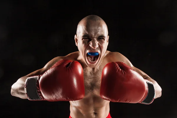The young man kickboxing on black  with kapa in mouth — Stock Photo, Image