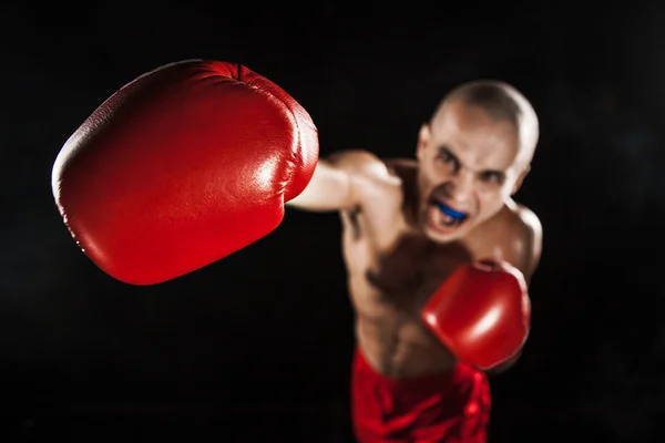 The young man kickboxing on black  with kapa in mouth — Stock Photo, Image