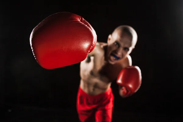 The young man kickboxing on black  with kapa in mouth — Stock Photo, Image