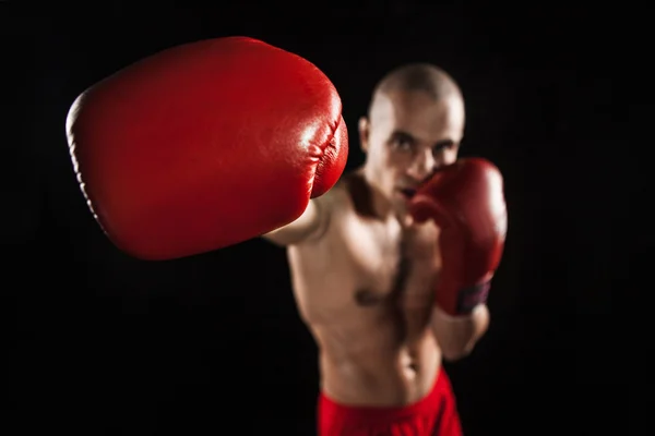 The young man kickboxing on black  with kapa in mouth — Stock Photo, Image