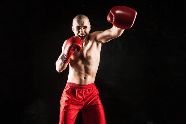 The young man kickboxing on black — Stock Photo, Image