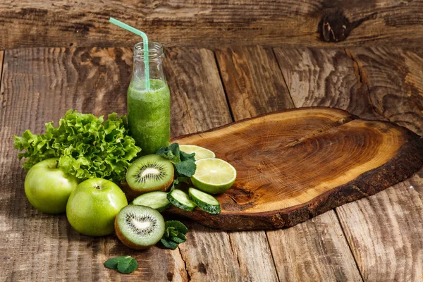 Láhve s čerstvé zeleninové šťávy na dřevěný stůl — Stock fotografie