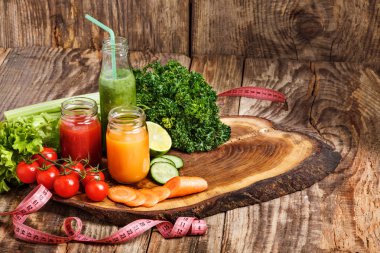 Ahşap masa üzerinde taze sebze suları ile şişe