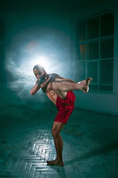 The young man kickboxing in blue smoke Royalty Free Stock Images