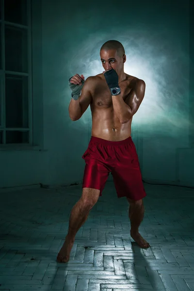 O jovem kickboxing em fumaça azul — Fotografia de Stock