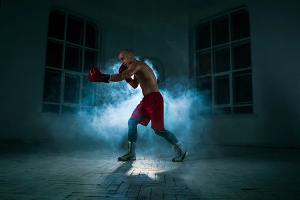Ο νεαρός άνδρας kickboxing στον μπλε καπνό — Φωτογραφία Αρχείου
