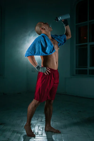 Siyah arka plan üzerine genç adam kickboxing — Stok fotoğraf