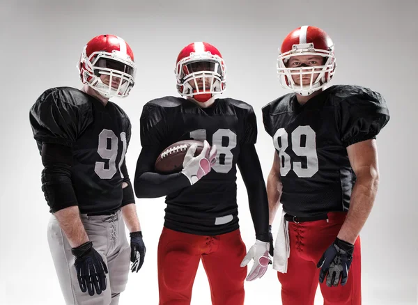 Les trois footballeurs américains posant avec le ballon sur fond blanc — Photo