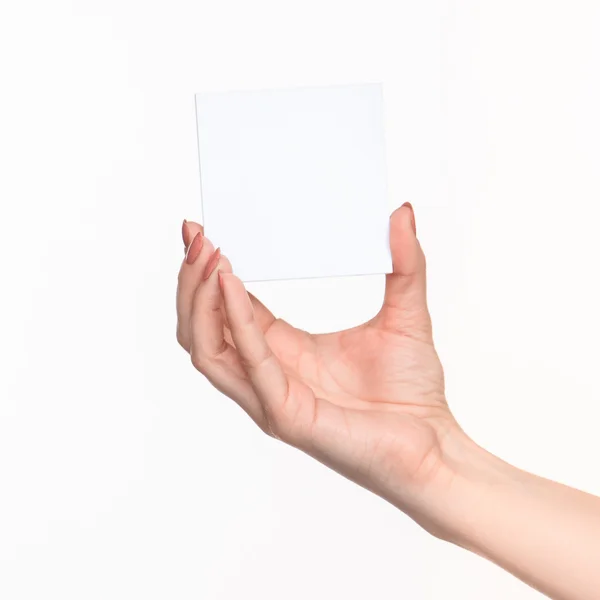 Ženská ruka drží prázdný papír pro záznamy na bílém pozadí. — Stock fotografie