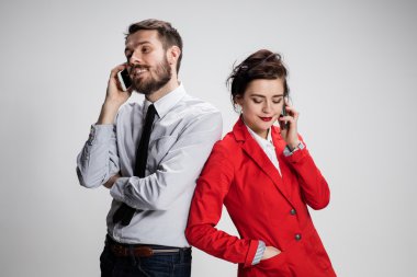 İş kavramı. Cep telefonu gri arka plan üzerinde tutan iki genç arkadaşları