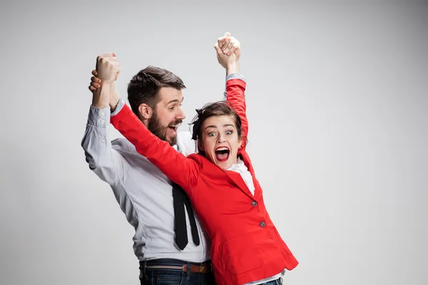 L'uomo e la donna d'affari ridono su uno sfondo grigio — Foto Stock