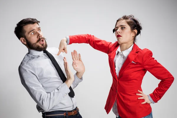 Грустный бизнесмен и женщина конфликтуют на сером фоне — стоковое фото