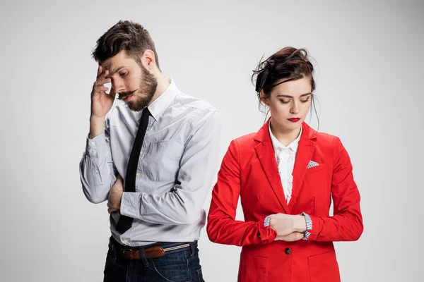 The sad business man and woman conflicting on a gray background — Stock Photo, Image