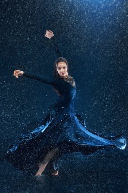 Genç güzel modern dansçı su damlaları altında