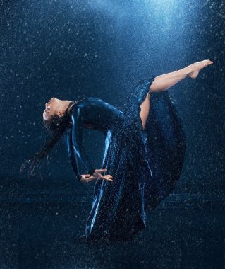 Genç güzel modern dansçı su damlaları altında
