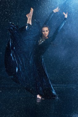 Genç güzel modern dansçı su damlaları altında