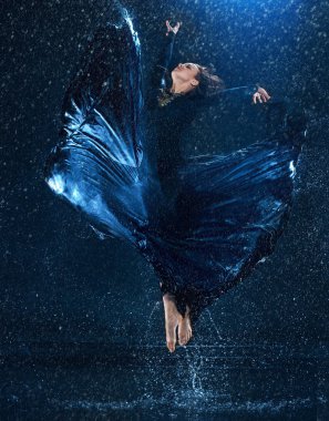 Genç güzel modern dansçı su damlaları altında