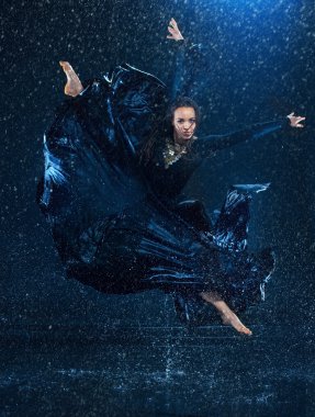 Genç güzel modern dansçı su damlaları altında