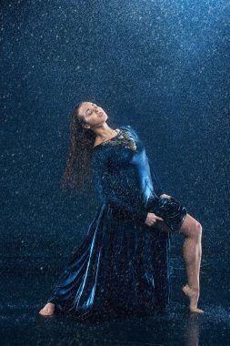 Genç güzel modern dansçı su damlaları altında