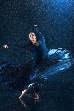 Genç güzel modern dansçı su damlaları altında