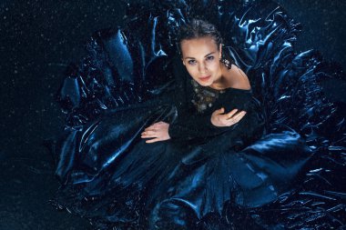 Genç güzel modern dansçı su damlaları altında poz