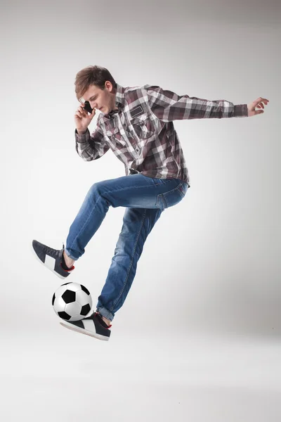 Ritratto di giovane con smart phone e pallone da calcio — Foto Stock