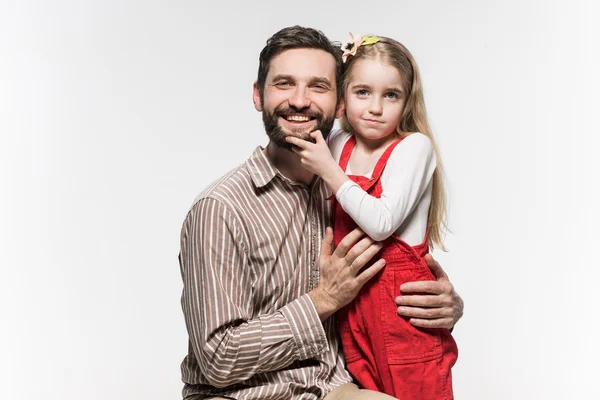 Menina abraçando seu pai sobre um fundo branco — Fotografia de Stock