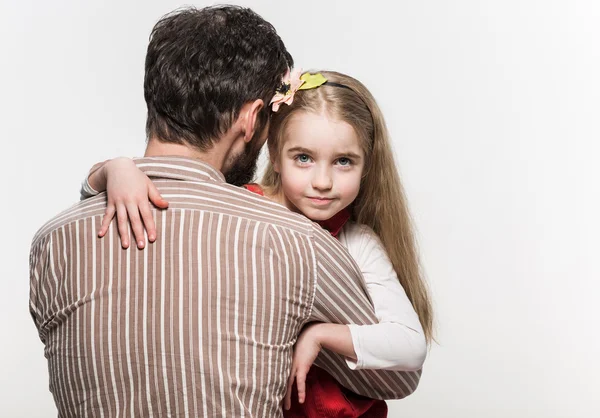 Chica abrazando a su padre sobre un fondo blanco —  Fotos de Stock