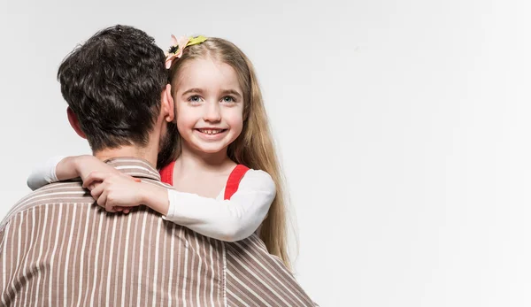 Gadis yang memeluk ayahnya di atas latar belakang putih — Stok Foto