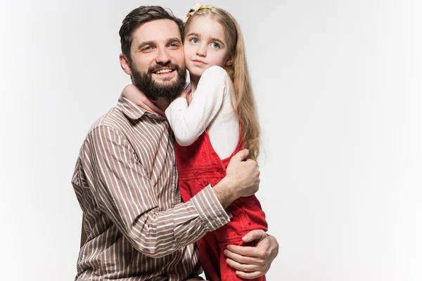 Menina abraçando seu pai sobre um fundo branco — Fotografia de Stock