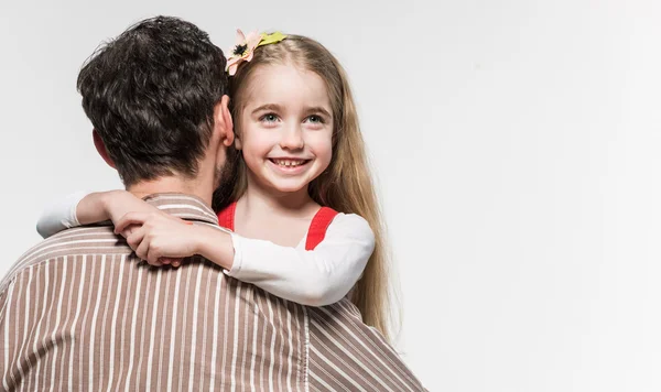 Meisje die haar vader knuffelen op een witte achtergrond — Stockfoto