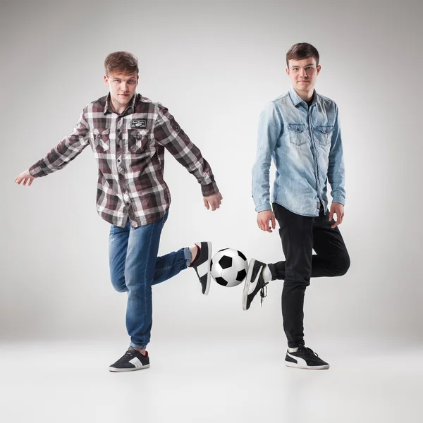 De twee jongens met ballen op grijze achtergrond — Stockfoto