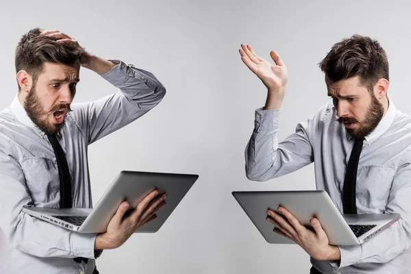 Il giovane uomo confuso e frustrato con il suo computer portatile — Foto Stock