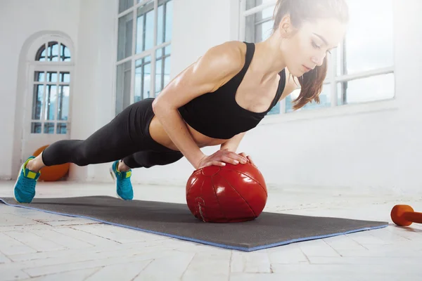 Hermosa morena delgada haciendo gimnasia en el gimnasio — Foto de Stock