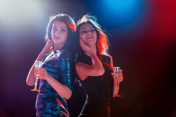 Duas meninas bonitas dançando na festa bebendo champanhe — Fotografia de Stock