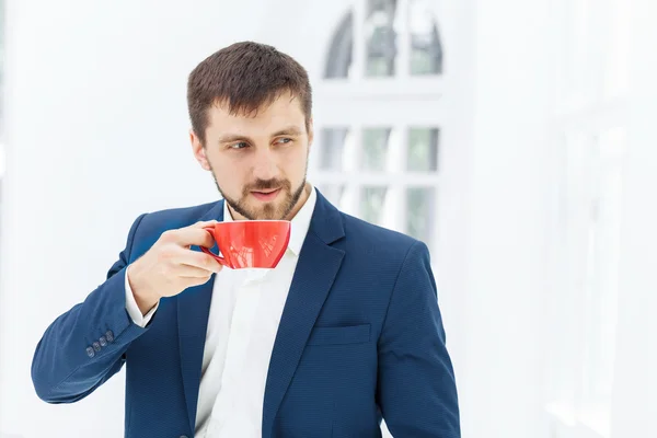 Zakenman met koffiepauze, hij houdt een kop — Stockfoto