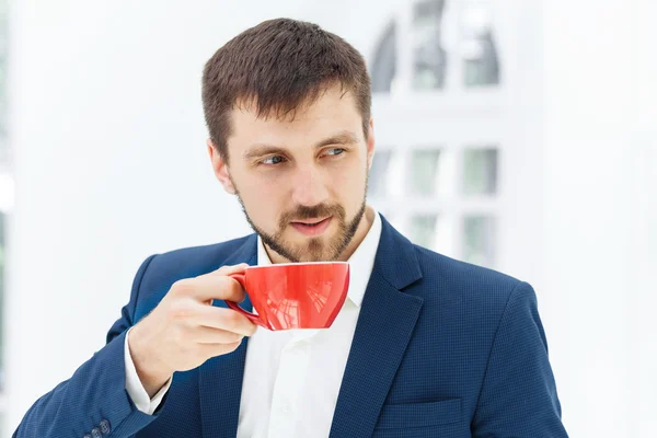Бізнесмен має перерву на каву, він тримає чашку — стокове фото