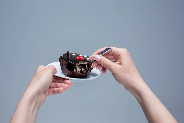 Frauenhände halten Kuchen mit Löffel grau — Stockfoto