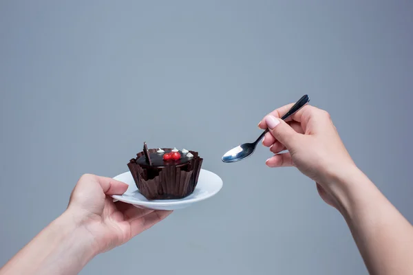 Frauenhände halten Kuchen mit Löffel grau — Stockfoto