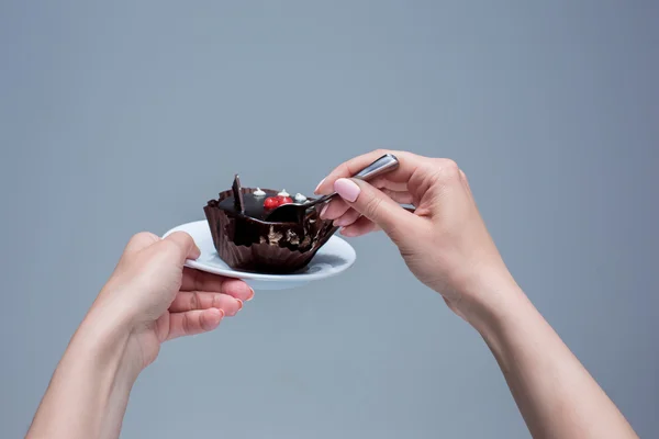 Frauenhände halten Kuchen mit Löffel grau — Stockfoto