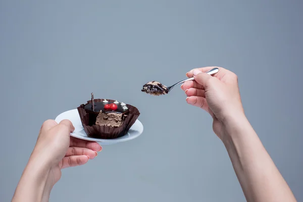 Frauenhände halten Kuchen mit Löffel grau — Stockfoto