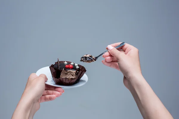 Frauenhände halten Kuchen mit Löffel grau — Stockfoto