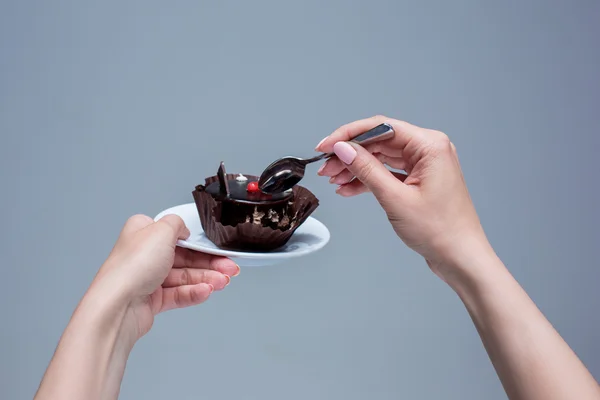 Frauenhände halten Kuchen mit Löffel grau — Stockfoto