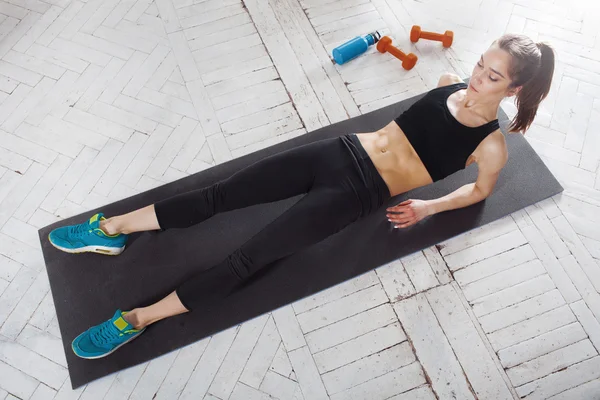 Beautiful slim brunette  doing some stretching exercises in a gym — Stock Photo, Image