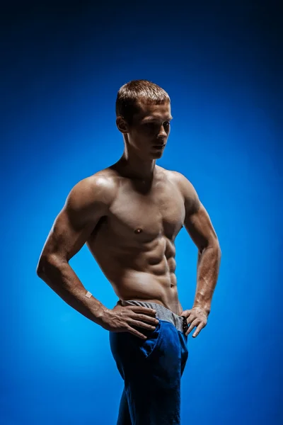 Ajuste joven con hermoso torso sobre fondo azul —  Fotos de Stock