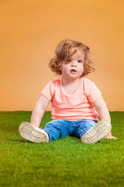 Turuncu zemin üzerine bir şirin bebek kız — Stok fotoğraf