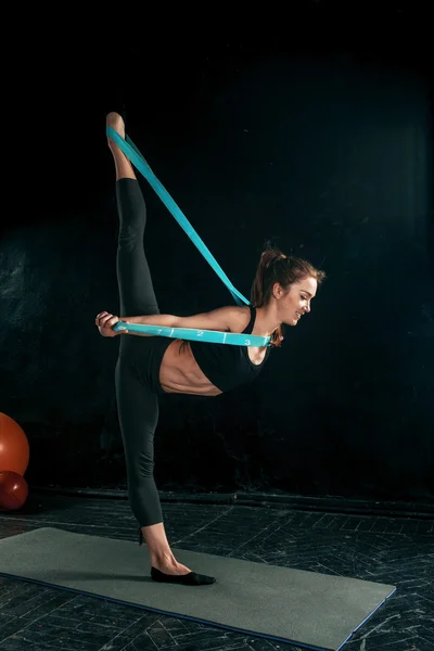 Die brünette athletische Frau, die mit Gummiband trainiert — Stockfoto